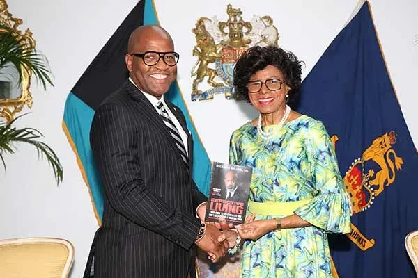 Councilman Ricardo Miller of Red Oak, Texas, presents a copy of his book to the Governor General