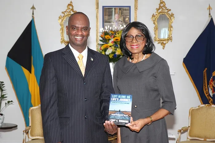 RBDF Captain Glenn Edward McPhee presents a copy of his book to the Governor General