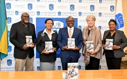 Deputy Prime Minister Cooper presents copies of his book to the University of The Bahamas