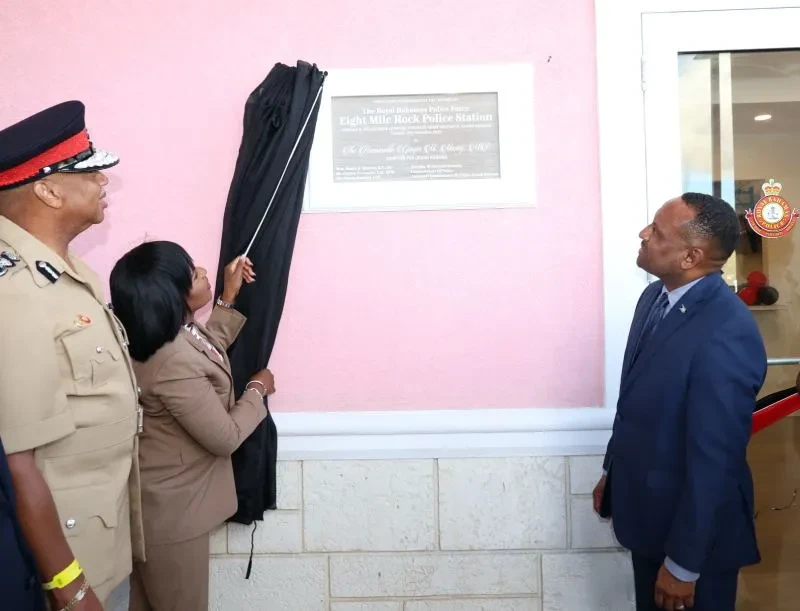 UNVEILS PLAQUE – Minister for Grand Bahama, THE Hon. Ginger Moxey unveils the plaque on the new Eight Mile Rock Police Station during official opening ceremonies on Tuesday, November 12, 2024, in the Obadiah Wilchcombe Complex.  Looking on is Commissioner of Police Clayton Fernander (left) and Member of Parliament for West Grand Bahama and Bimini, Kingsley Smith.