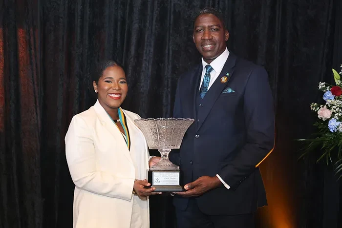 <strong>Ms. Kaché Hanna</strong> receives the 2024 Prime Minister’s Cup from Minister of State in the Ministry of Environment and Natural Resources and Governor-General representative the Hon. Zane Lightbourne; at the recent Nominee Medal Presentation and National Youth Awards Ceremony, held at Evangelistic Temple, on October 29, 2024. <br/> (BIS Photo/Eric Rose)